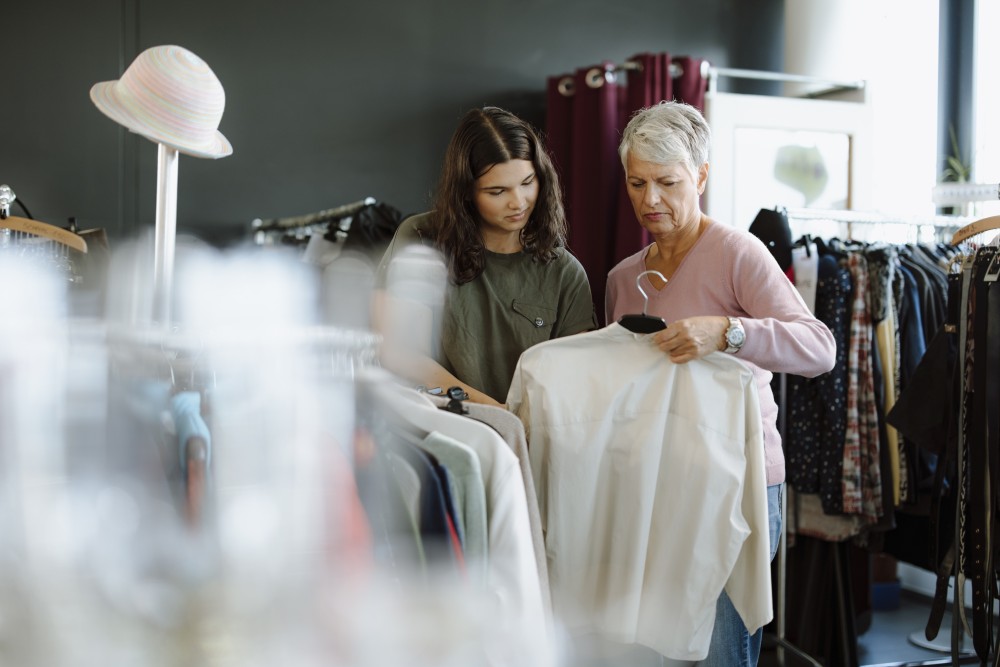 Zwei frauen suchen in einem Geschäft Kleidung aus