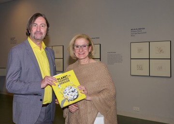 Landeshauptfrau Johanna Mikl-Leitner mit Karikaturist Michael Pammesberger bei der Ausstellungseröffnung „Planet Pammesberger“.