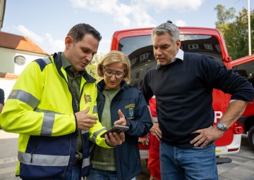 Bürgermeister Jürgen Rummel, Landeshauptfrau Johanna Mikl-Leitner und Bundeskanzler Karl Nehammer machen sich Bild von der Lage in Neulengbach.