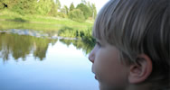 Kind schaut über einen See hinweg
